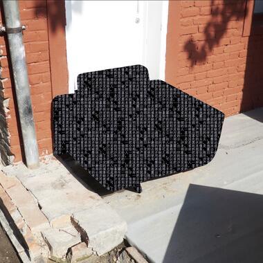 Image of one of Steven's photographs exhibited in his thesis work. The photograph shows an airmchair up against the exterior of a building. The chair has been redacted and is instead shown in black with white Chinese characters that describe the chair.