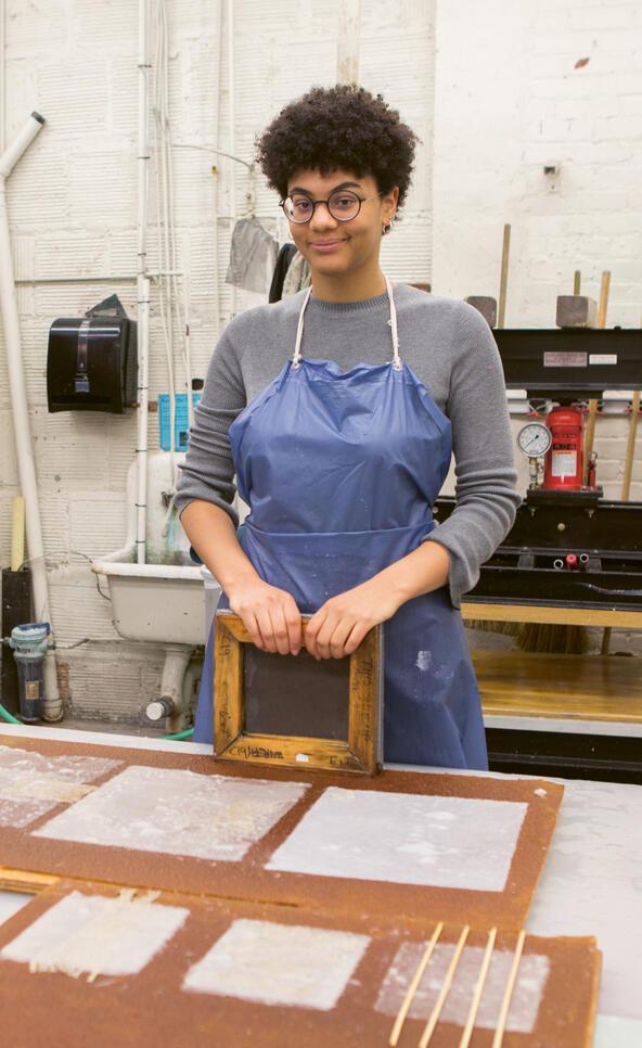 Student standing with their in-progress work