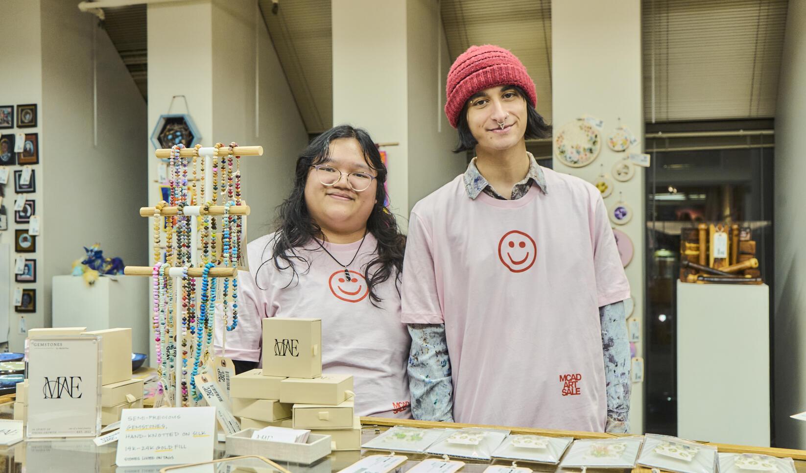 Two students working at the MCAD Art Sale