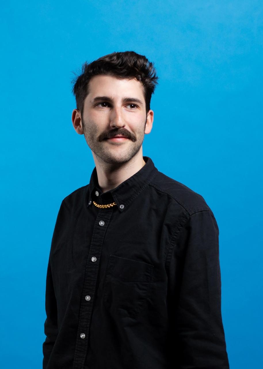 Portrait of Isaac Ruder against a blue background.