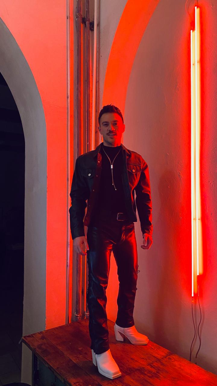 Jonathan Rodriguez stands in a room lit with red light