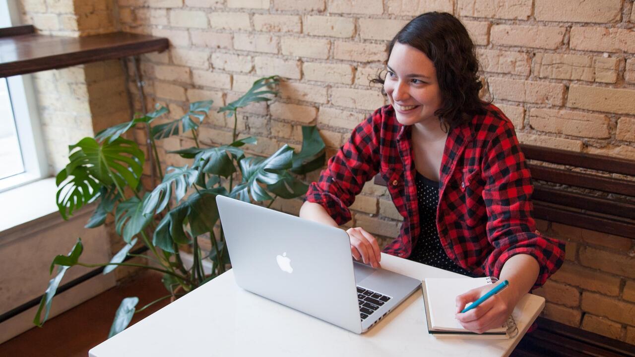 Student working in coffee shop at computer