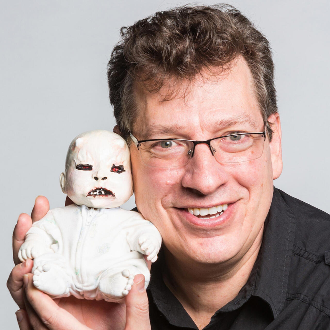 Rueff holding a demonic looking baby doll