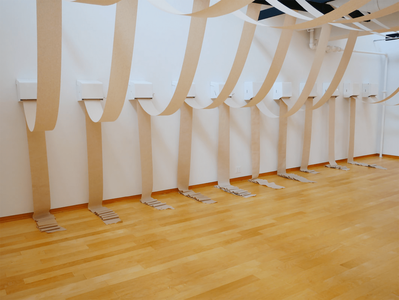 An image of a gallery consisting of paper towel dispensers tethered via their paper.