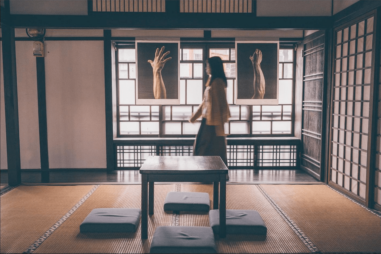 An image of pictures of hands presented in a traditional teahouse-like setting.