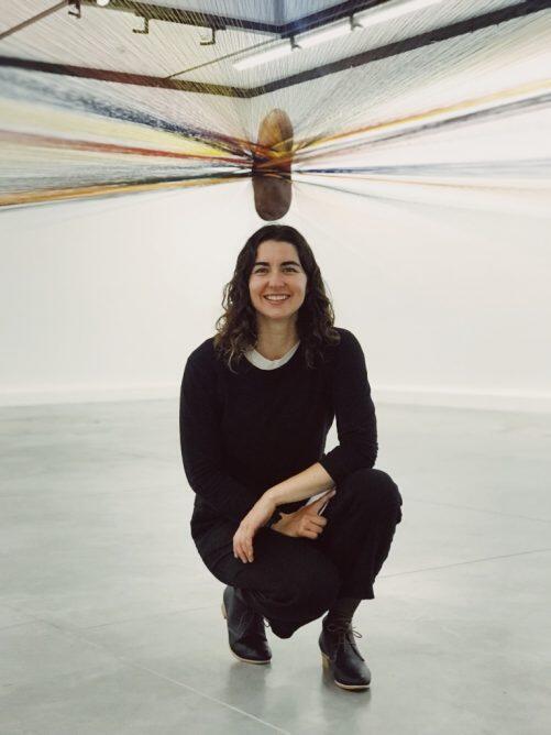 Jennifer O'Connell posing in front of a yarn sculpture 