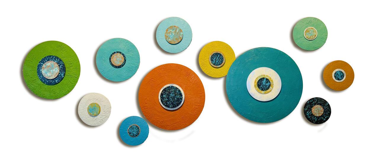 Encaustic and metallic paints on acrylic panels done by Jodi Reeb. They are circular and range from green, to orange, to teal.