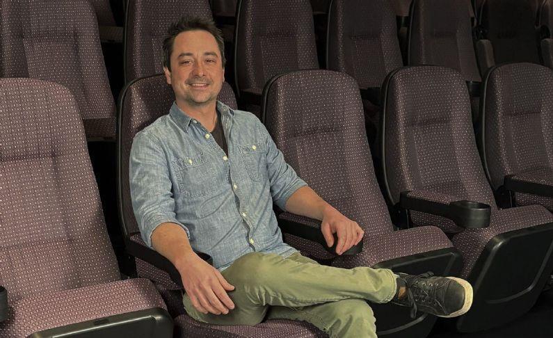 A Photo of Lucas Hall sitting in an auditorium of the Spring Grove Cinema.