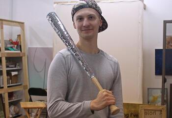 Photograph of Jacob Schroeder holding his baseball bat art piece