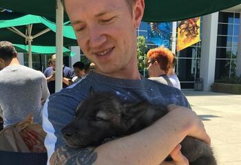 Photograph of Chris Havranek holding a wolf pup.