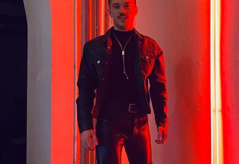 Jonathan Rodriguez stands in a room lit with red light